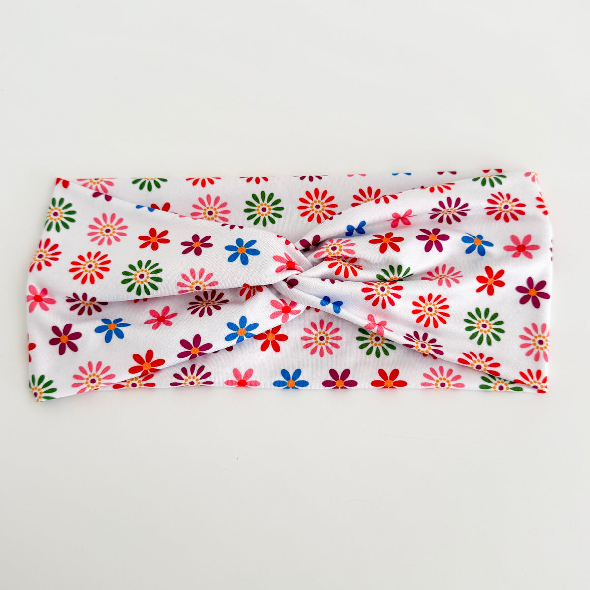 Colorful flowers Day of the Dead twist headband laid flat on white