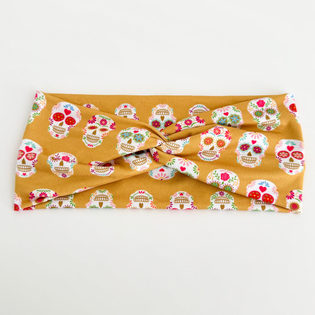Sugar skull Day of the Dead twist headband laid flat on white