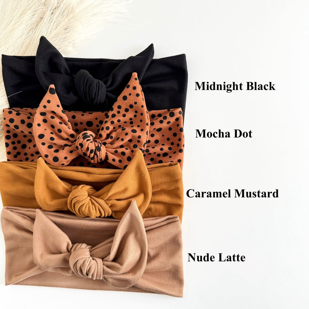 Headband Studio adjustable tie headbands in black, mocha dot, caramel mustard, and nude latte. Soft fabric, knotted style.
