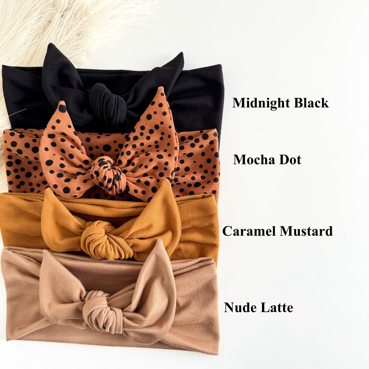 Headband Studio adjustable tie headbands in black, mocha dot, caramel mustard, and nude latte. Soft fabric, knotted style.