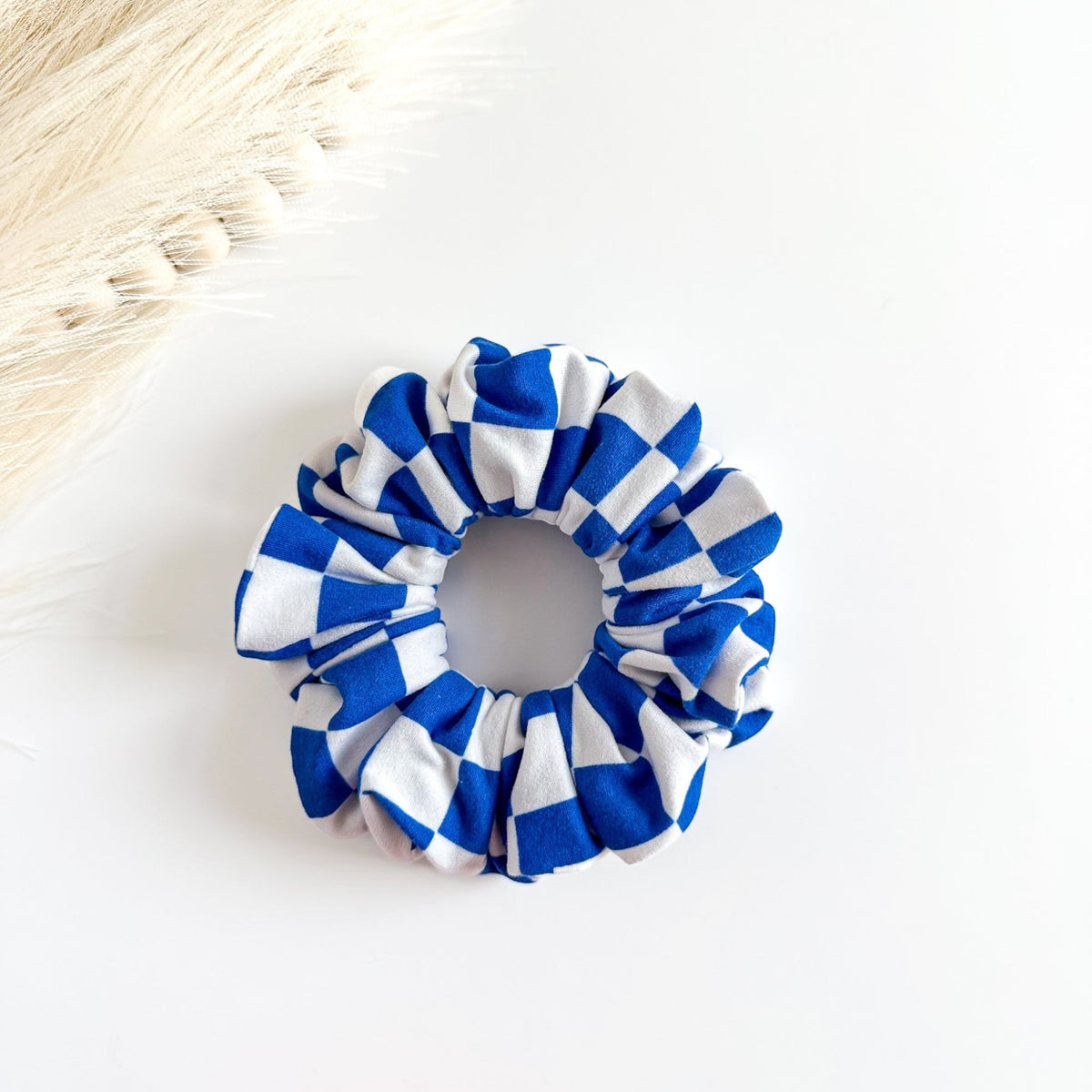 Blue and white checkered scrunchie on a light surface
