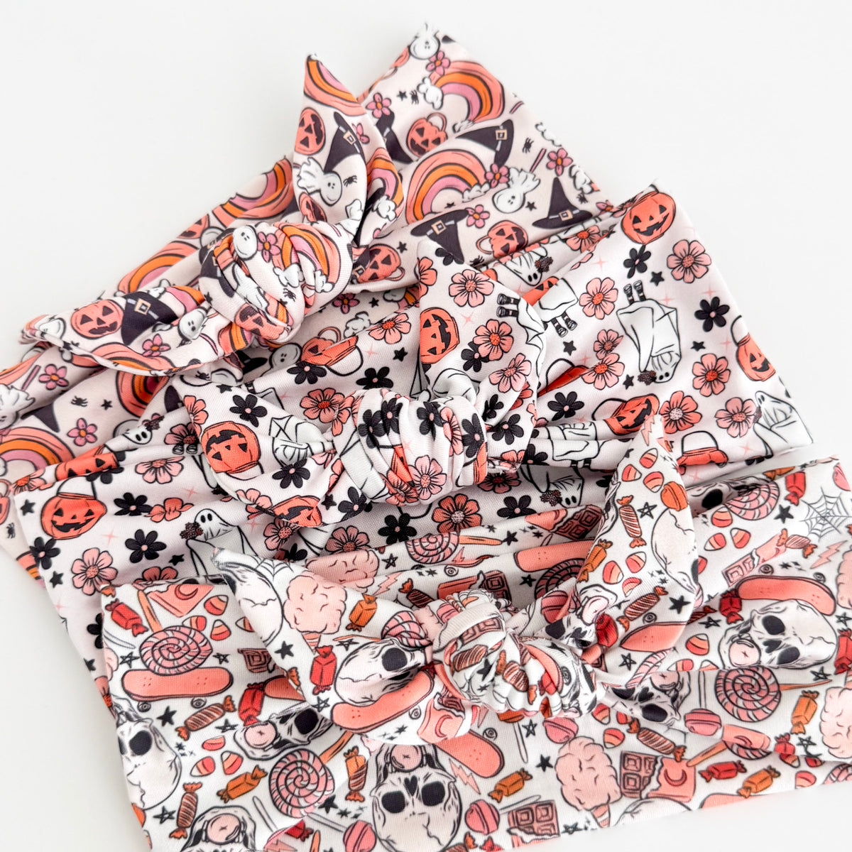Three Halloween knotted tie headbands on white: Spooky Sweet Skulls, Spooky Sweet Ghost and Halloween Rainbows