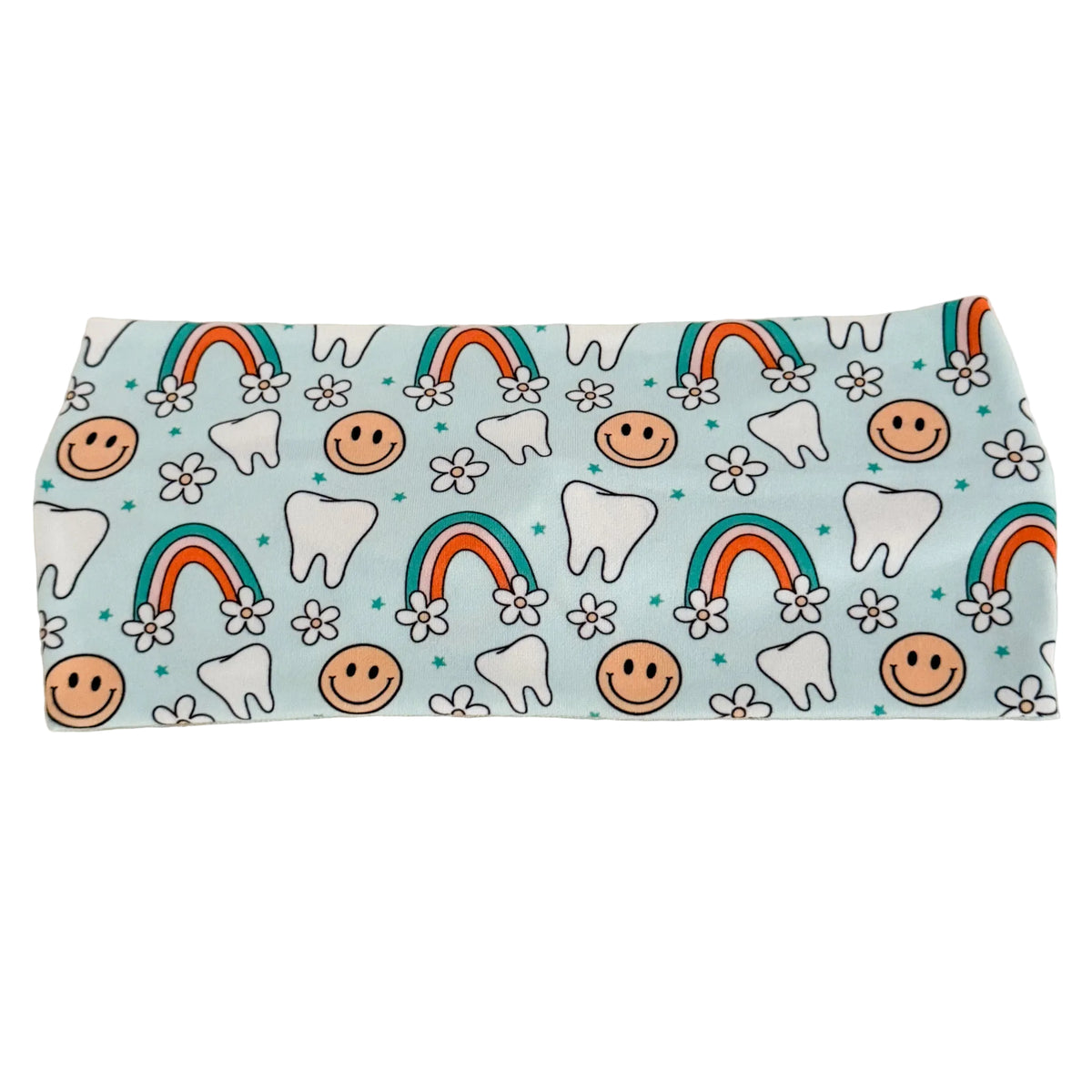 Fabric with tooth, smiley face, and rainbow pattern on a light blue background