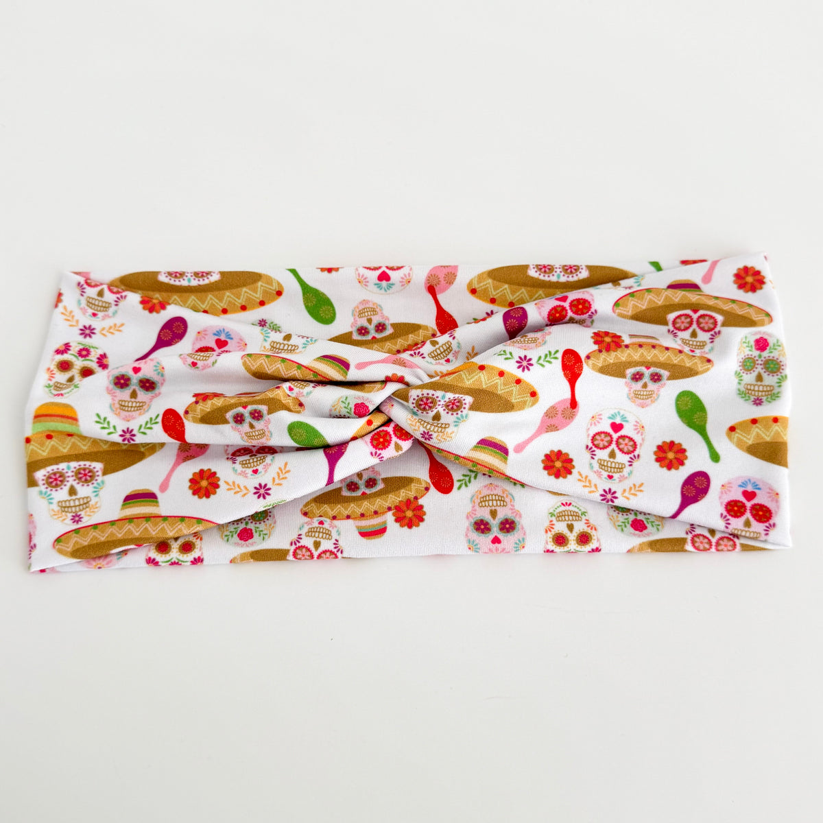 Sombreros & maracas Day of the Dead twist headband laid flat on white