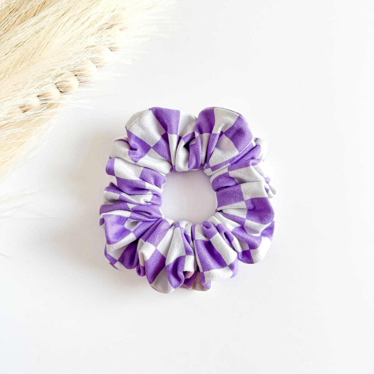 Purple and white checkered scrunchie on a light background