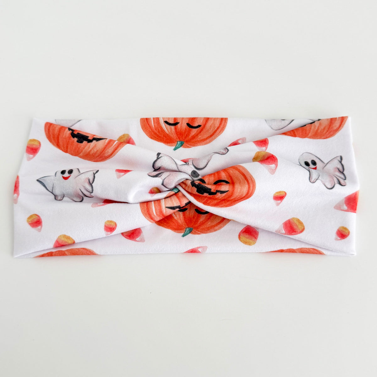 Pumpkin and Candy Corn twist headband with pumpkins, ghosts and candy corn on white