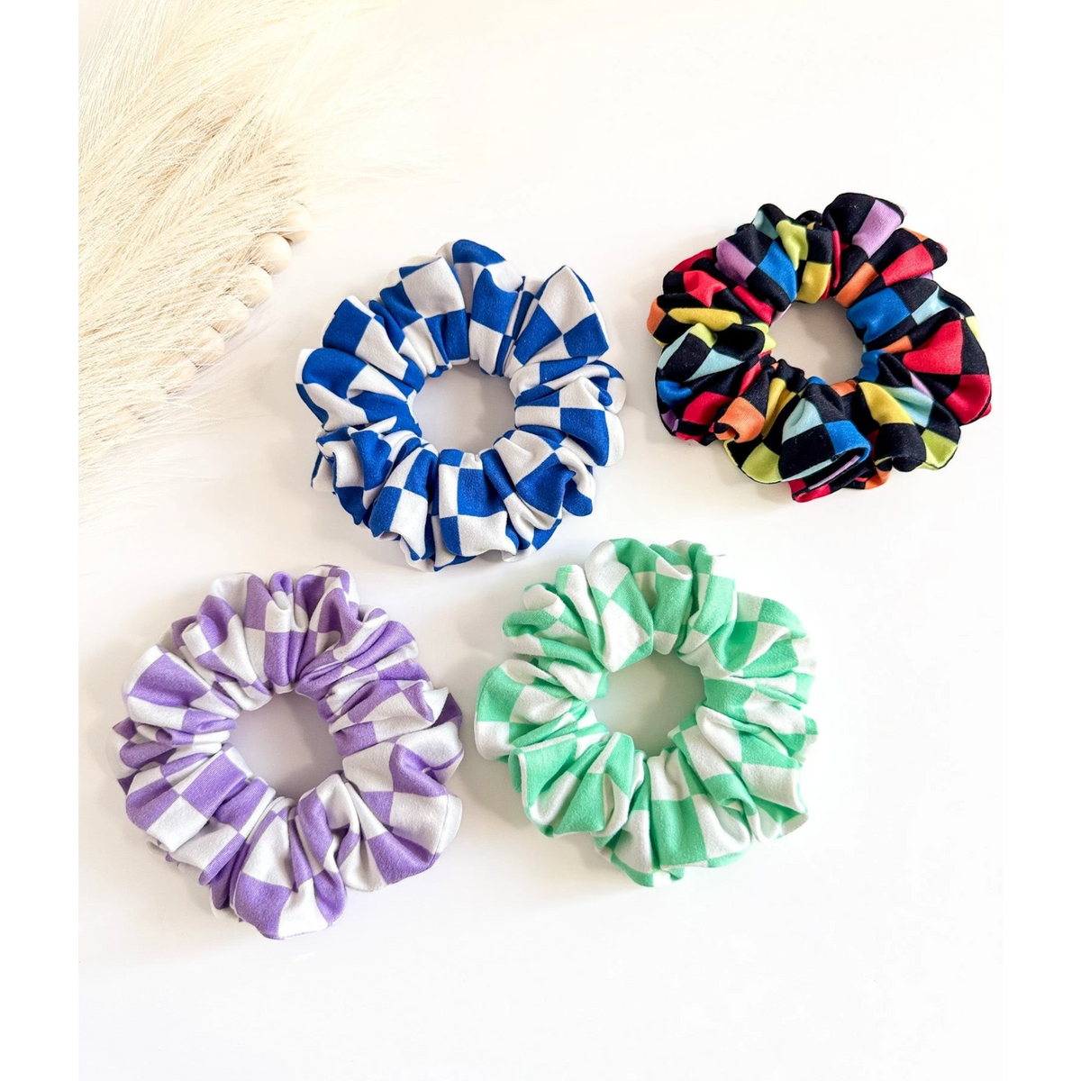 Four colorful scrunchies on a white background