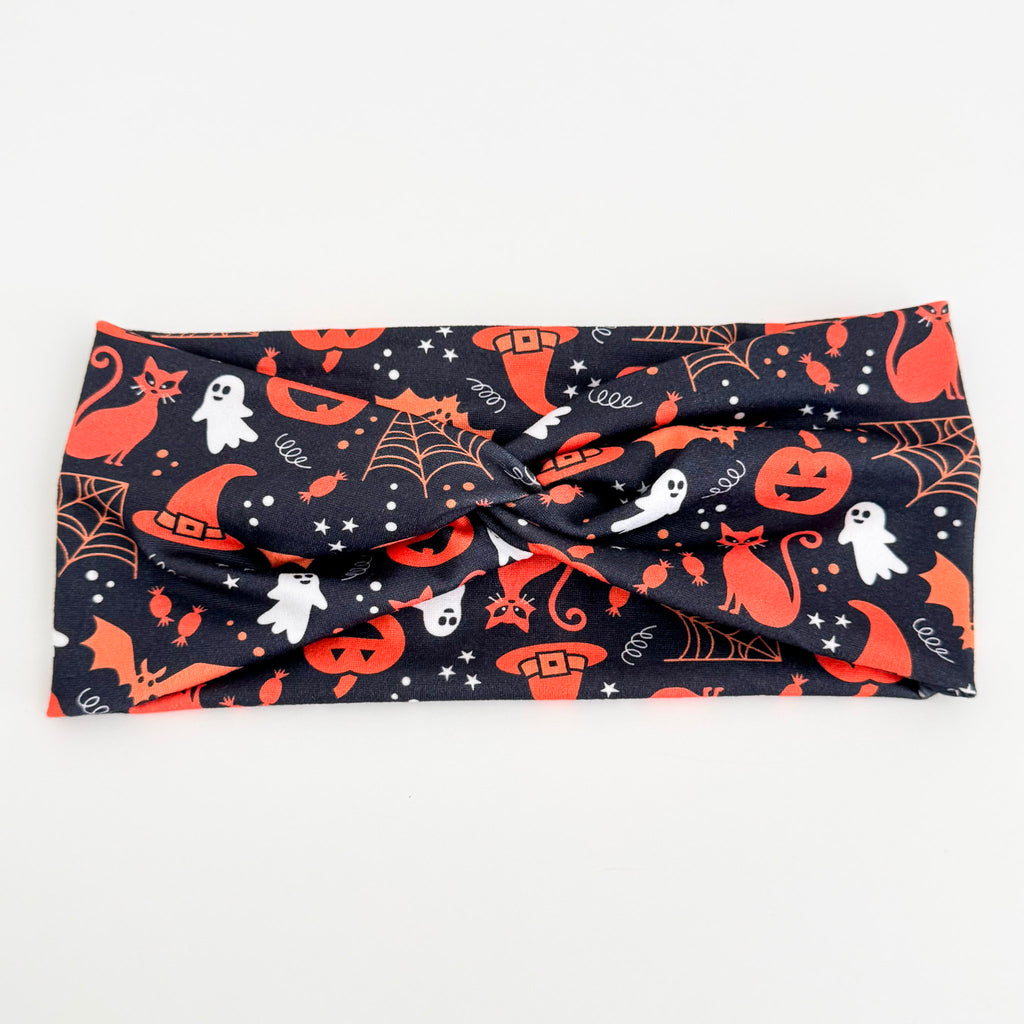 Witchy Night twist headband with black cats, spider webs, pumpkins and ghosts on navy