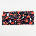 Witchy Night twist headband with black cats, spider webs, pumpkins and ghosts on navy