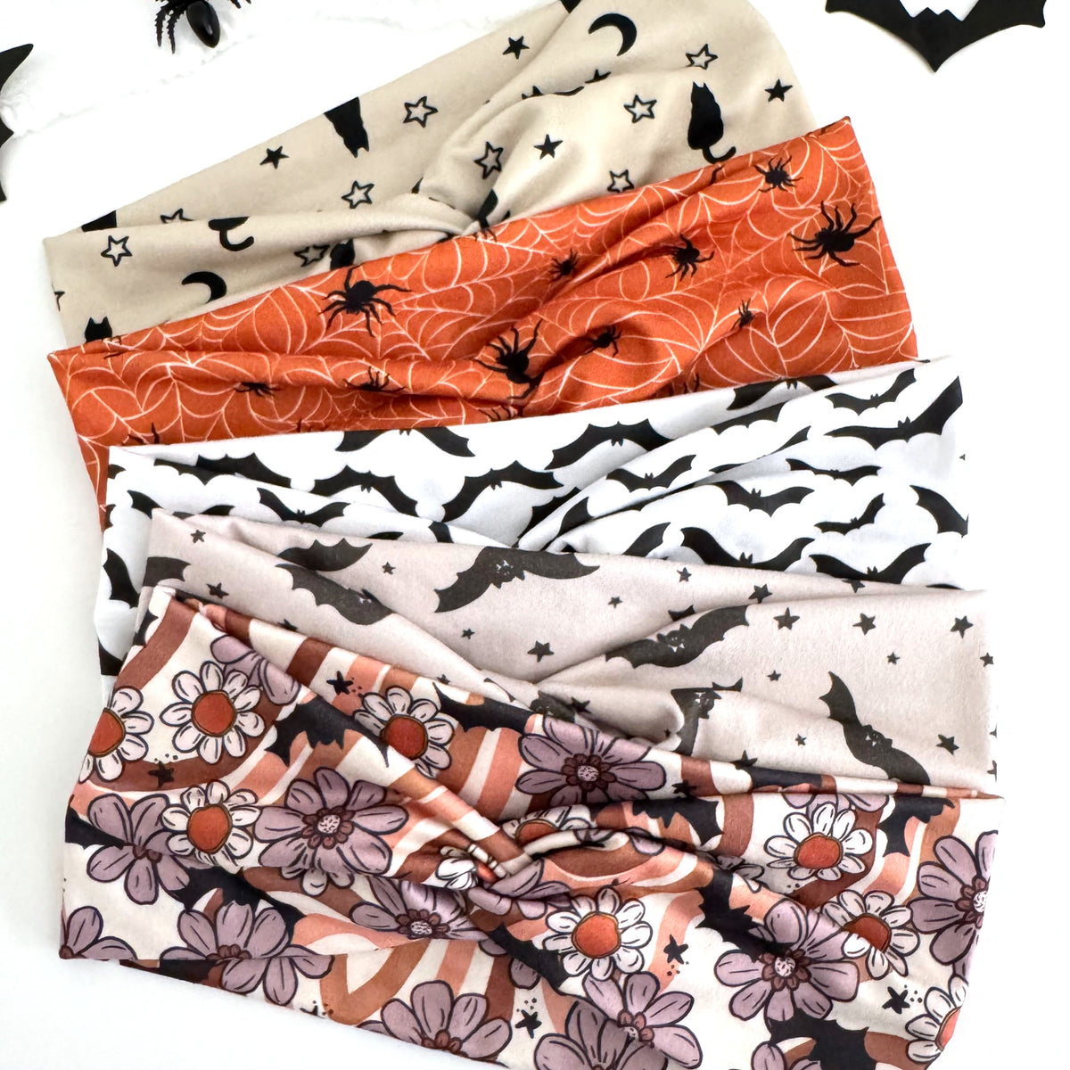 Bat and Spider Halloween twist headbands fanned out with paper bats and spiders