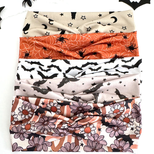 Bat and Spider twist headbands stacked: Black Cat and Moon, Spider Webs, Black and White Bats, Starry Bats and Floral Bats