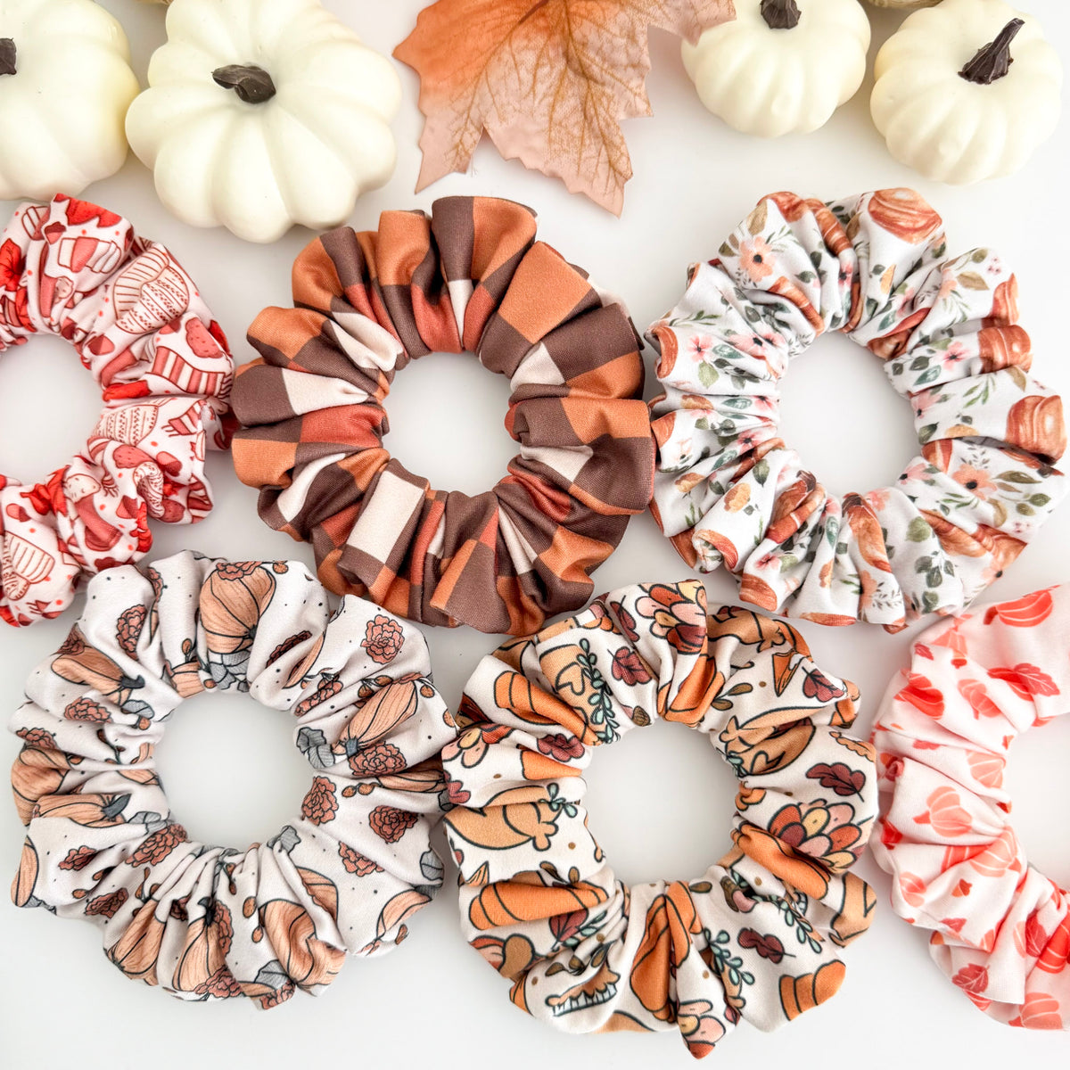 Fall scrunchies in pumpkin, checkered, floral and Thanksgiving prints with white pumpkins