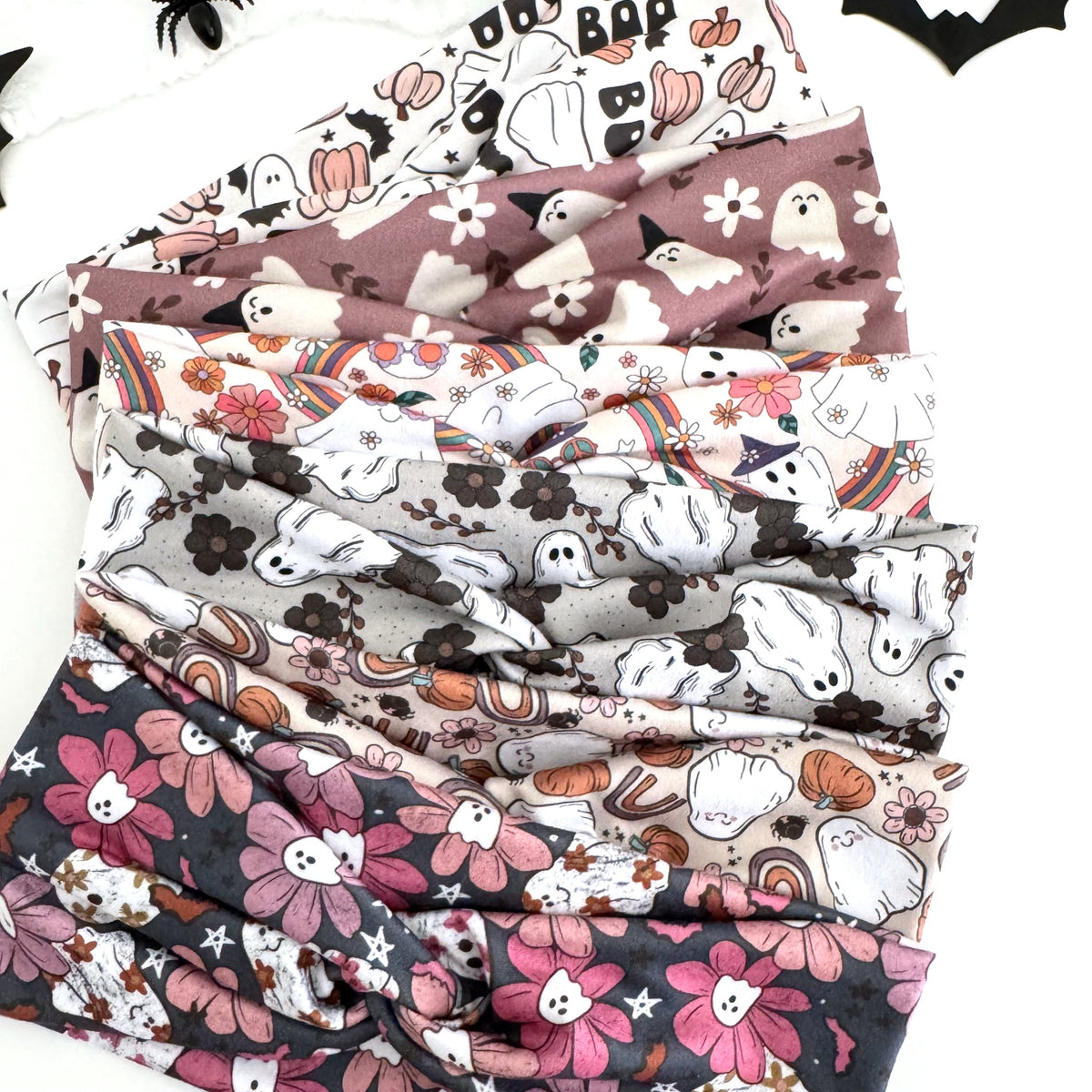 Ghost Halloween twist headbands fanned out with paper bats and spiders