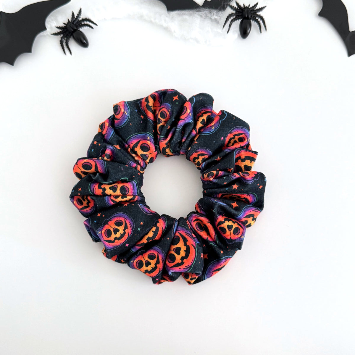 Glowing Jack-o'-Lanterns scrunchie with glowing pumpkin faces on navy