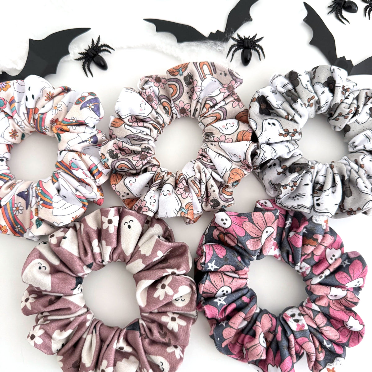 Ghost Halloween scrunchies in groovy, rainbow, pink and floral ghost prints with paper bats and spiders