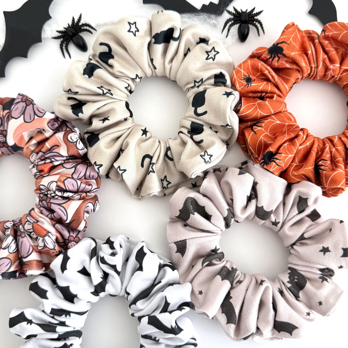 Bat and black cat Halloween scrunchies in starry bats, black cat and moon, spider webs and floral bats prints