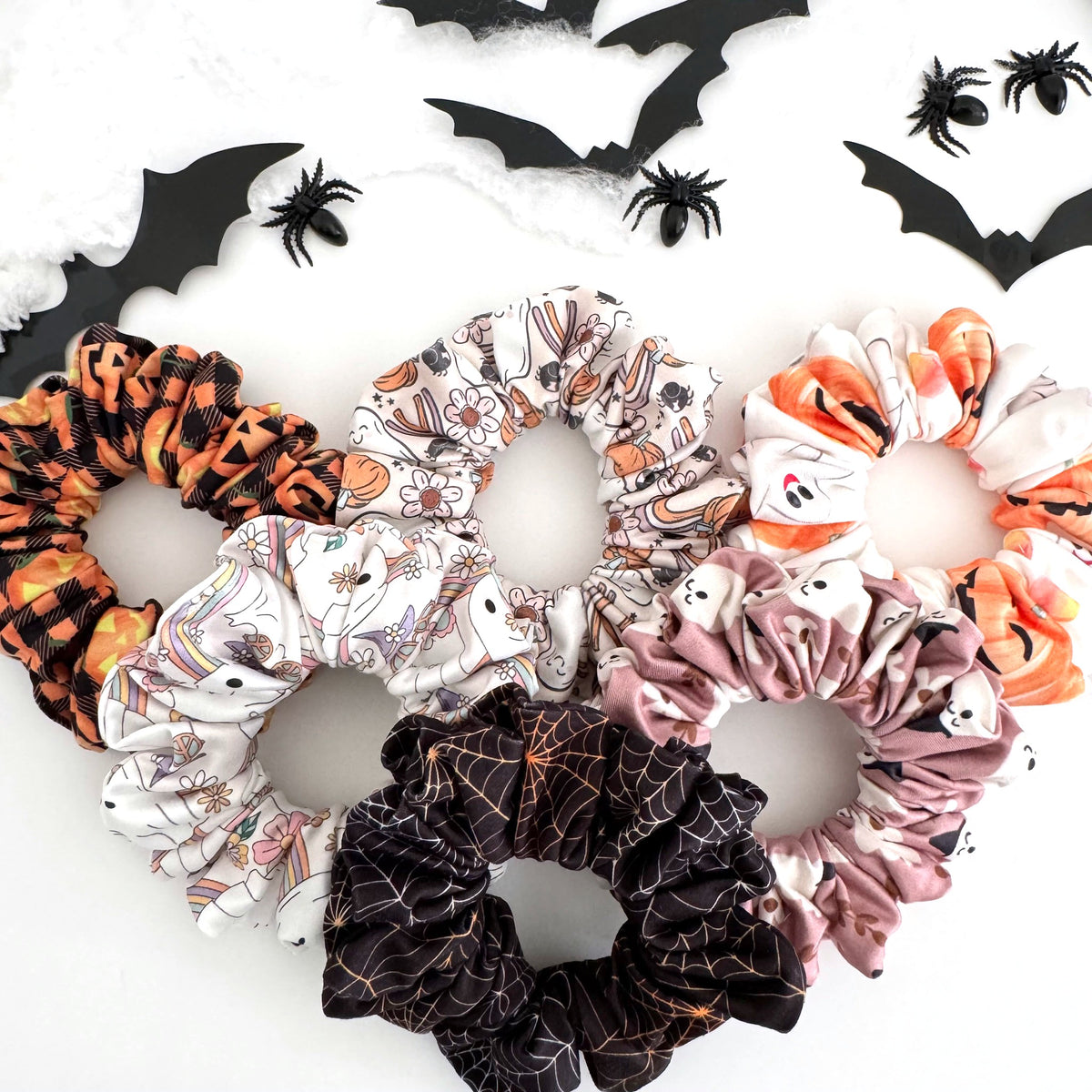 Halloween scrunchies in jack-o'-lantern plaid, pastel ghost, candy corn and spider web prints