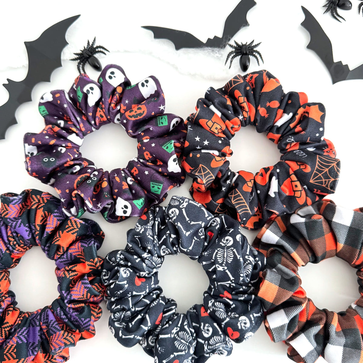 Spooky Night Halloween scrunchies in witchy, skeleton, purple and buffalo plaid prints with paper bats and spiders