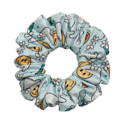 Headband Studio light blue scrunchie with a pattern of smiling teeth and small white flowers, made of soft polyester.