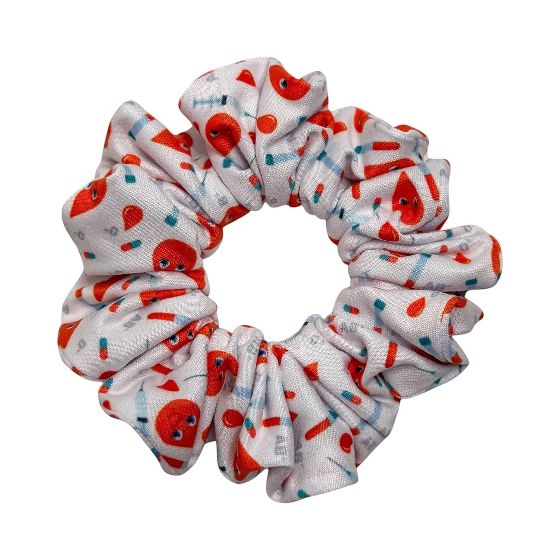 Headband Studio white scrunchie with red blood drop characters, syringes, and pills print. Handmade polyester hair accessory.