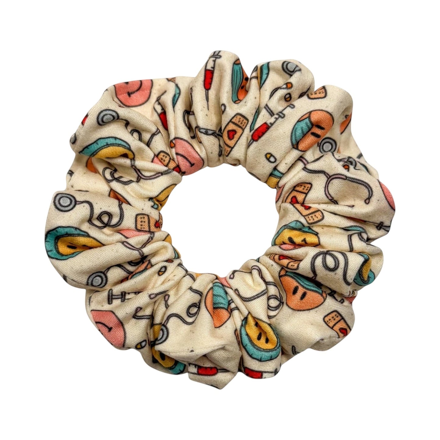 Headband Studio cream scrunchie with medical print: stethoscopes, syringes, band-aids, and smiley faces.