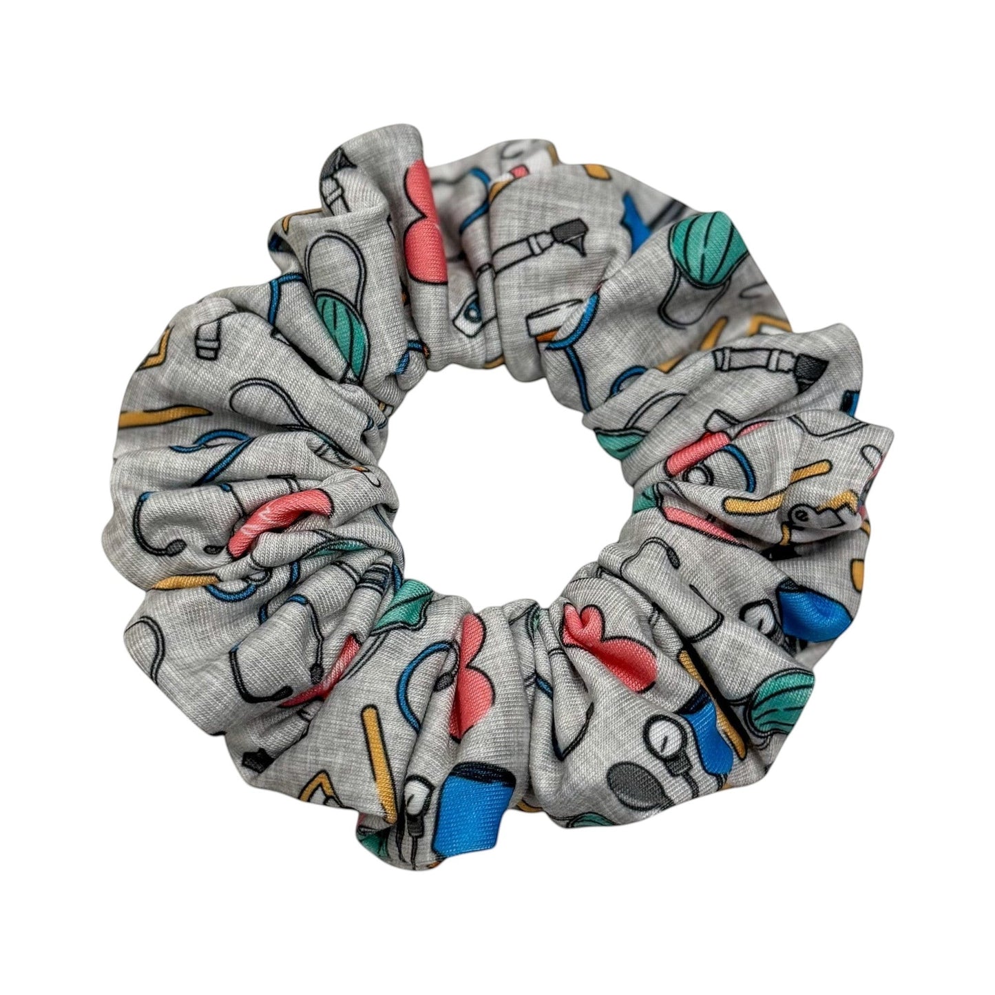 Headband Studio grey scrunchie with colorful medical icons like stethoscopes, heartbeats, and tools. Made of soft polyester.
