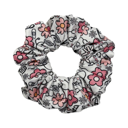 Headband Studio white scrunchie with pink flowers and medical icons like stethoscopes and masks.