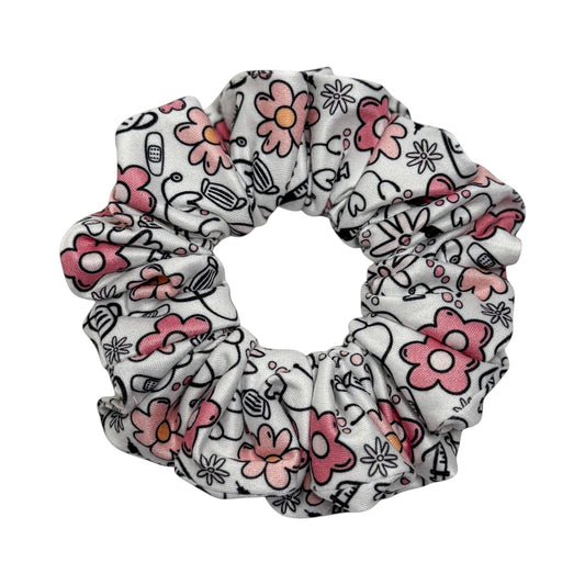 Headband Studio white scrunchie with pink flowers and medical icons like stethoscopes and masks.