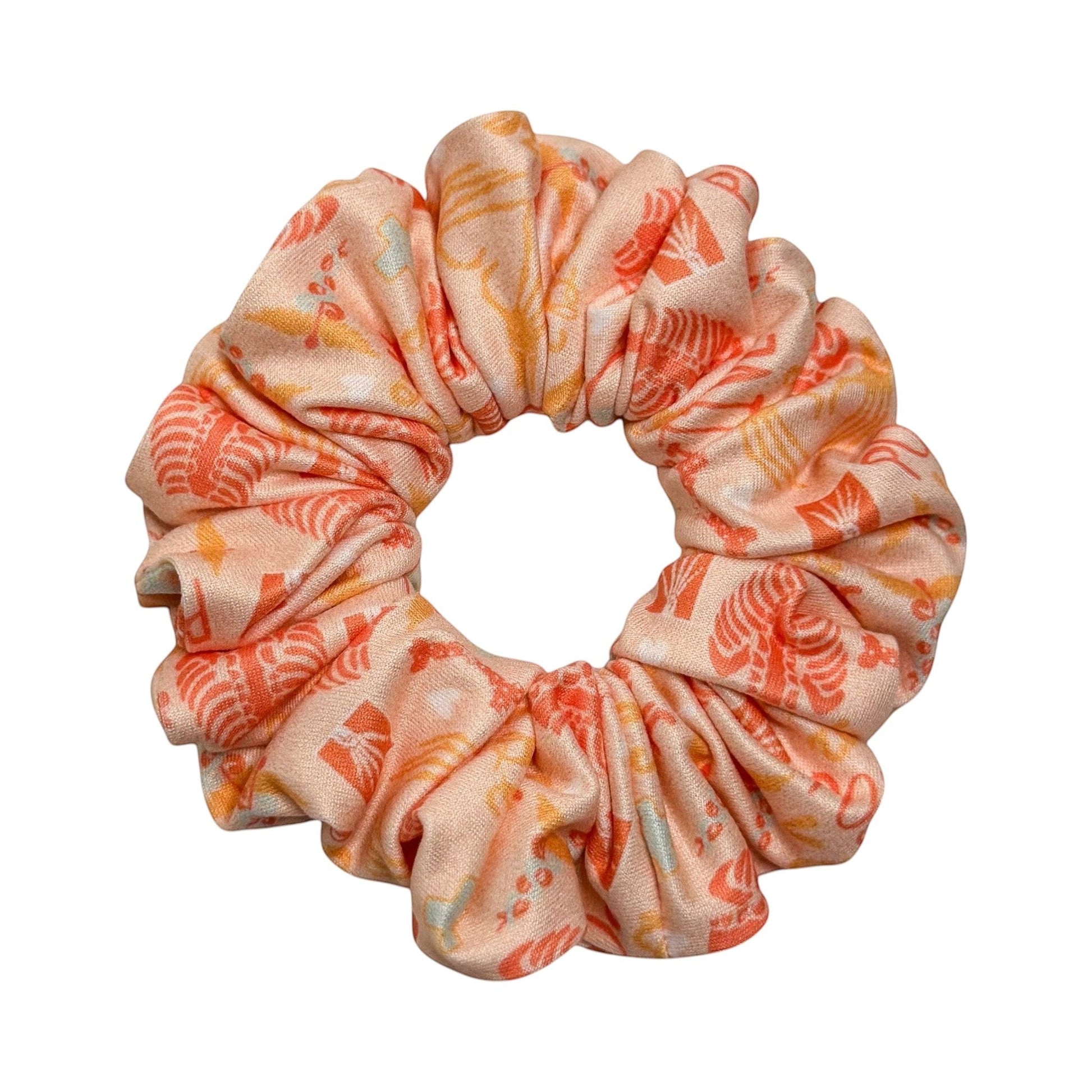 Headband Studio peach scrunchie with a repeating pattern of small medical icons in orange and yellow.