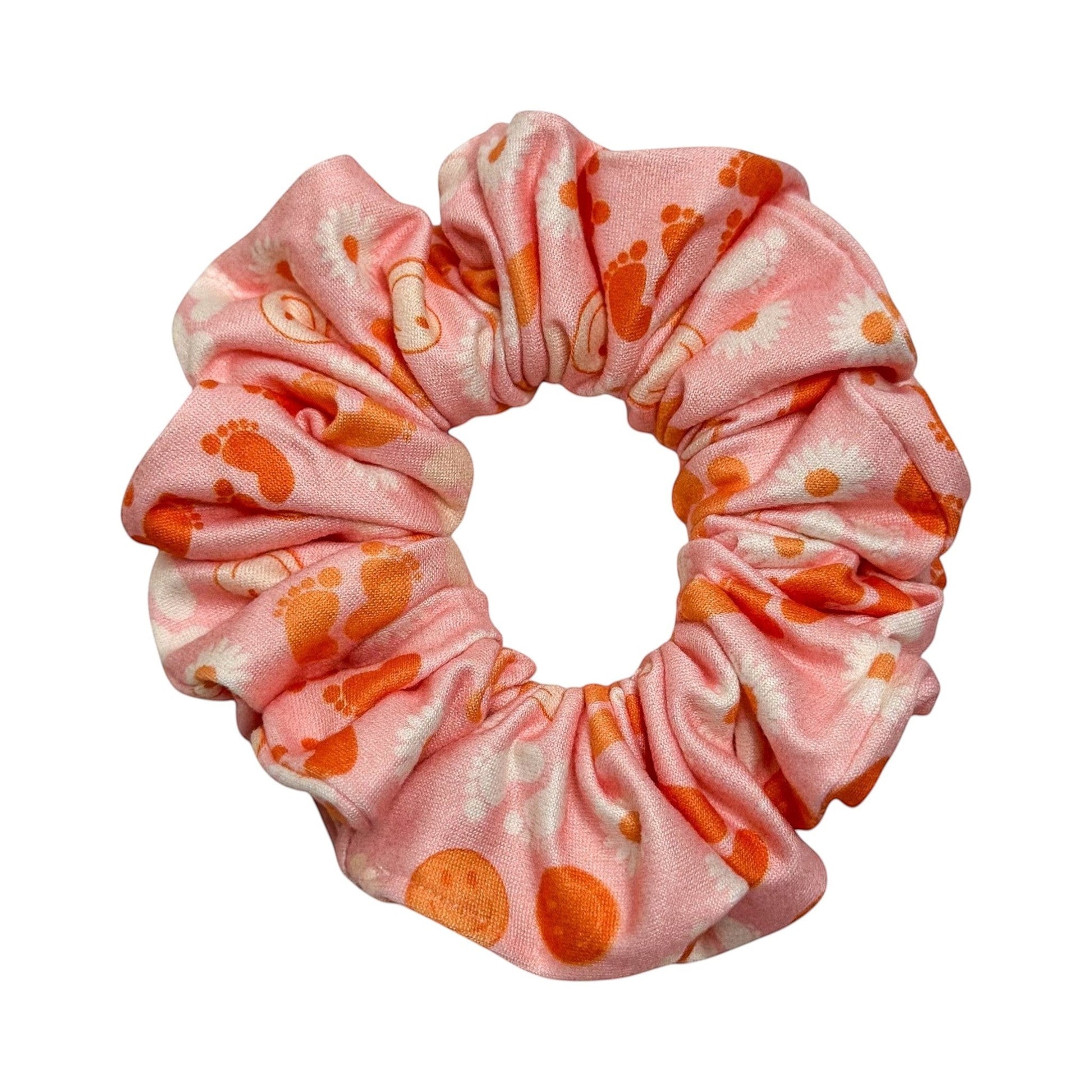 Headband Studio pink scrunchie with orange footprints and white daisies, made from soft polyester.