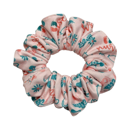 Headband Studio pink scrunchie with teal and coral medical-themed print including footprints and the word "nurse".