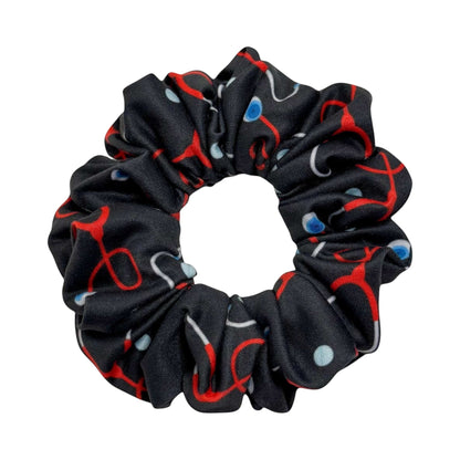 Headband Studio black scrunchie with red and blue stethoscope print, made of soft polyester for healthcare professionals.