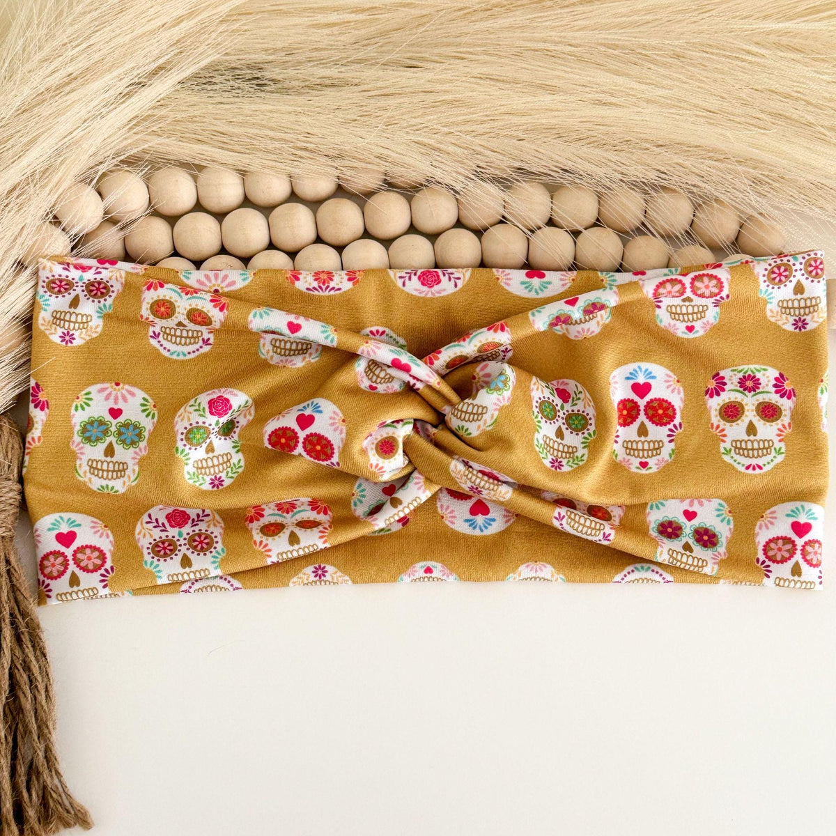 Sugar skull twist headband with white floral sugar skulls on mustard gold