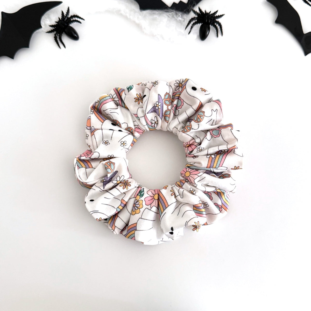 Pastel Groovy Ghost scrunchie with pastel ghosts, rainbows and flowers on white