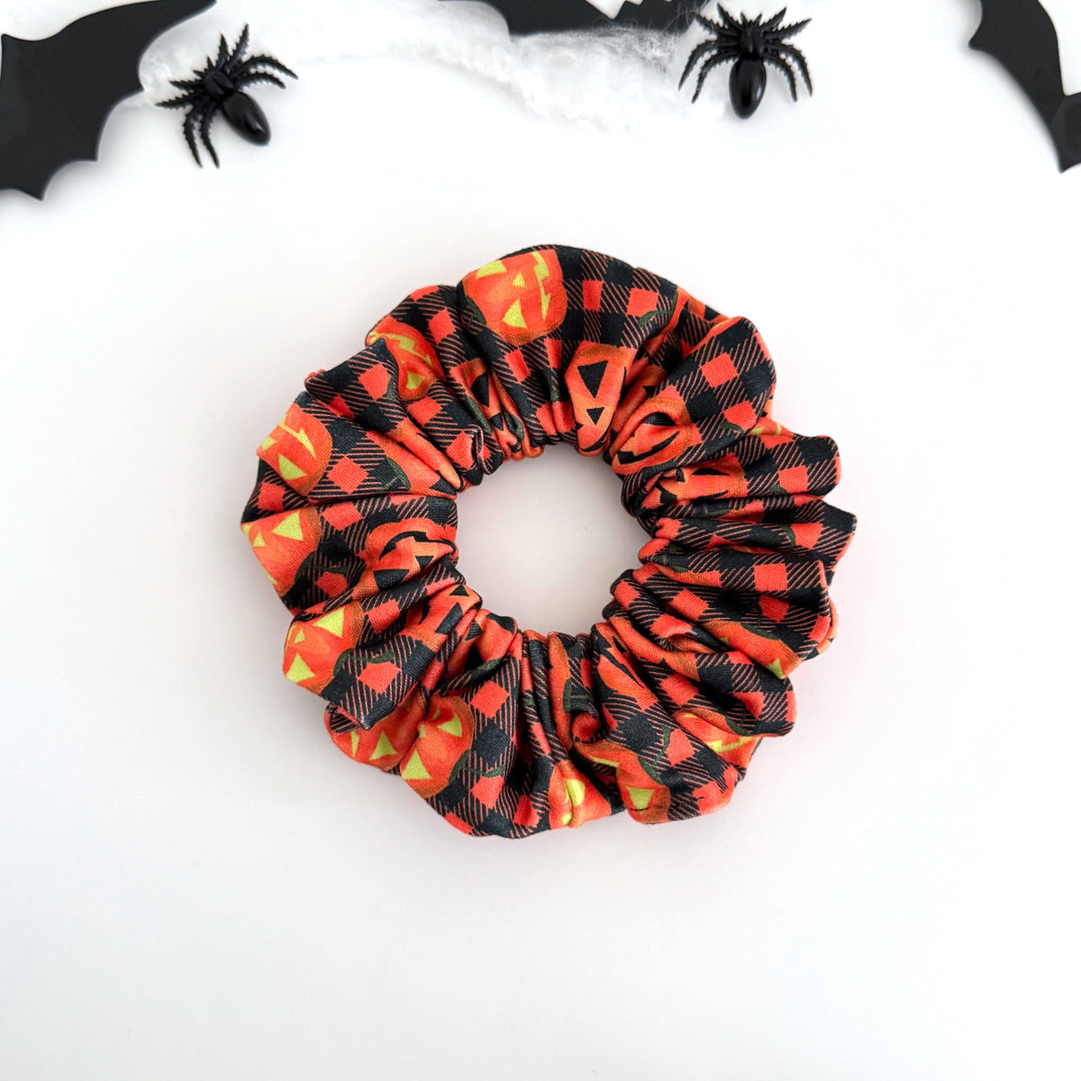 Plaid Pumpkin scrunchie with jack-o'-lanterns on orange and black buffalo plaid