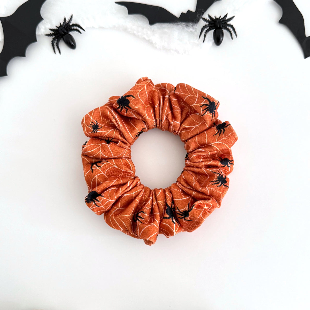 Spider Webs scrunchie with black spiders and webs on orange