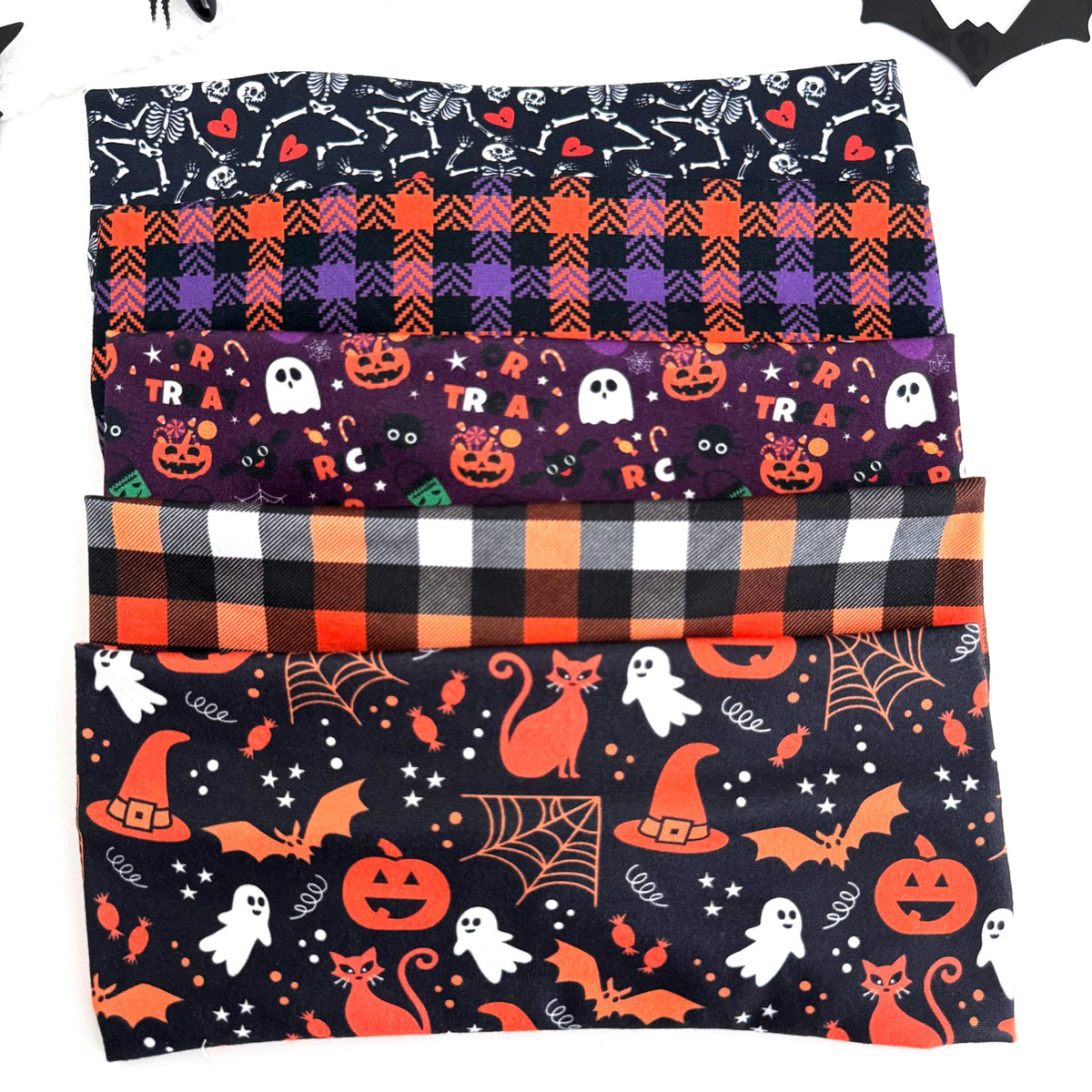 Spooky Night twist headbands stacked: Skeleton Sweethearts, Purple and Orange Plaid, Trick or Treat Purple, Halloween Buffalo Plaid and Witchy Night