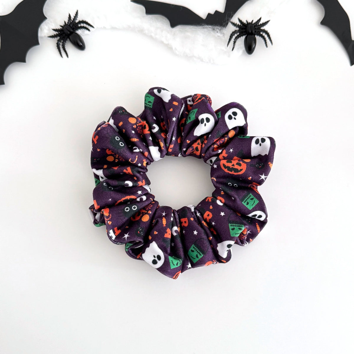Trick or Treat Purple scrunchie with ghosts, jack-o'-lanterns and candy on purple